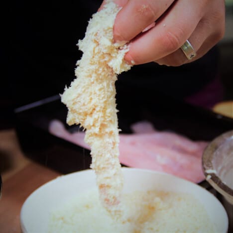 The flathead tail is being removed from a bowl of Panko breadcrumbs.