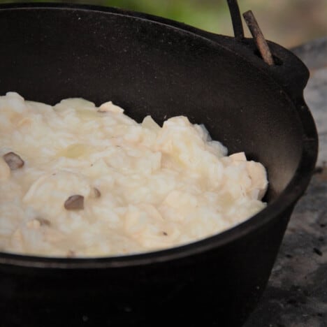 Looking into a Dutch oven that holds a large recipe of Campfire Mock Risotto.