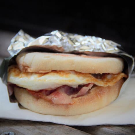 A ready to eat bacon and egg muffin is wrapped in foil.