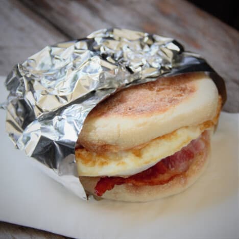 A quick and easy bacon and egg muffin is wrapped in foil and ready to serve.