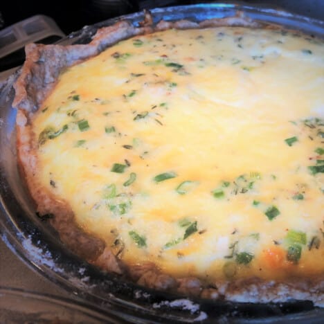 A full quiche is out of the camp oven and ready to be sliced and served.