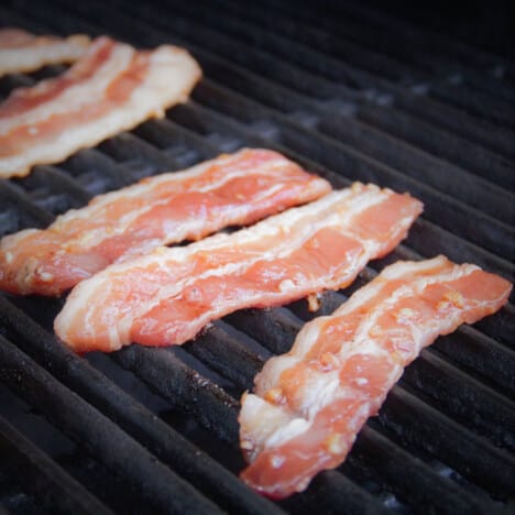 Thinly sliced pork belly is on the grill after being marinated in Asian flavors.
