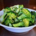 The sesame broccoli sitting in a white serving bowl garnished with black sesame seeds.