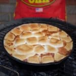 A finished easy chocolate s'mores pie still sitting in the barbecue.