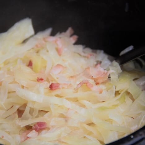Close up of the bacon and cabbage in the saucepan.