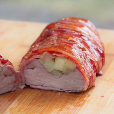 Bacon is wrapped around a pork tenderloin stuffed with fresh apples and glazed with barbecue sauce.