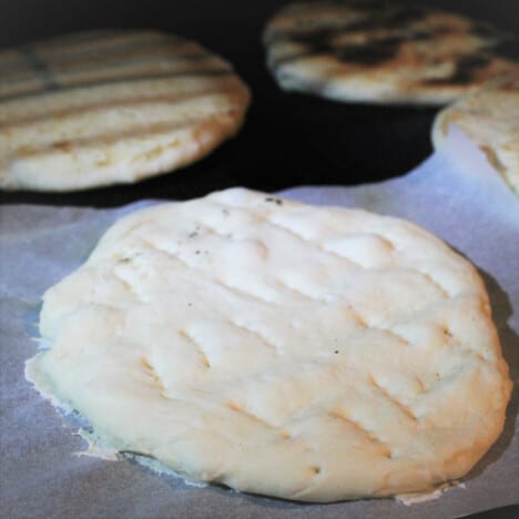 Pita bread is prepared and ready to cook on a flat top griddle barbecue.