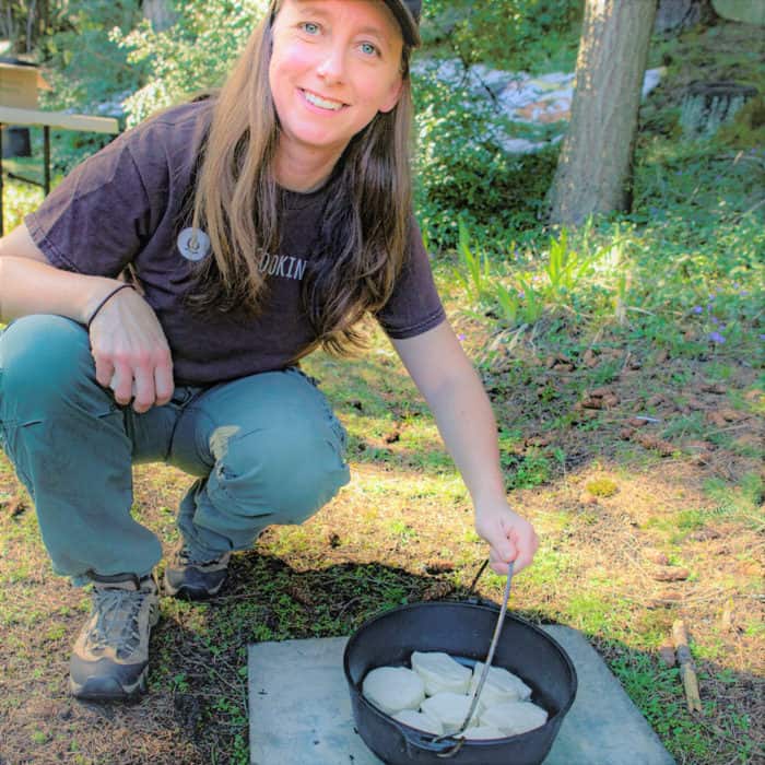 Saffron Hodgson with a Dutch oven with biscuits to bake