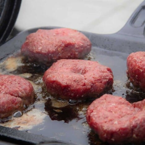Fice Burger Patties Cooking on a square skillet