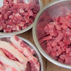 Three bowls of various types of meats, lean, marbled, and fat