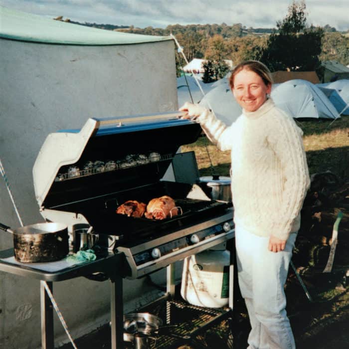 Saffron Hodgson opening a closed grill to expose the roast lamb and vegetables inside