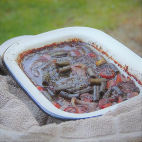 The beef steak casserole just after being taken off the heat, sitting in a kitchen towel.