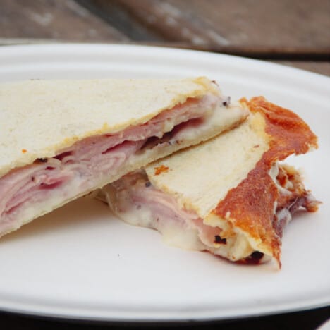 A cooked ham and cheese toasttie cut in half and ready to eat.