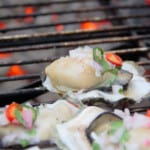 Grilled Mexican Oysters being cooked on a grill over live charcoal.