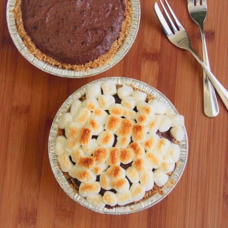 Looking down at two tarts, one with a browned marshmallow top the other just a chocolate tart without any marshmallows.