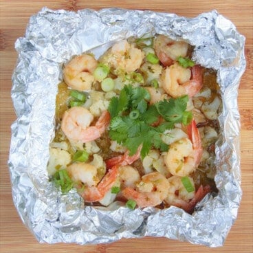 The square foil pack is opened up exposing the shrimp and cauliflower in Asian flavors in the inside.