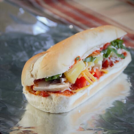 An assembled pizza roll, with the fillings visible, sits on a piece of foil waiting to be wrapped.