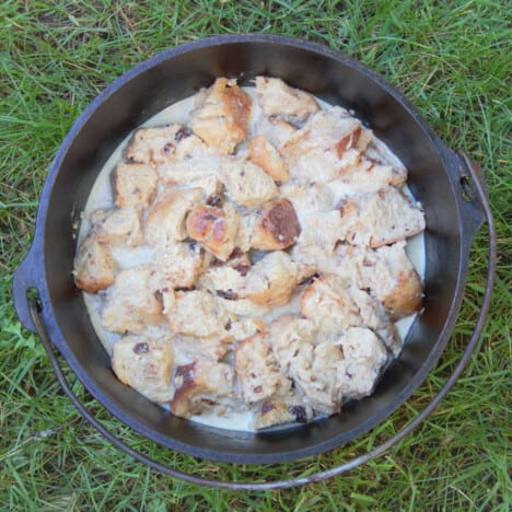 Looking down on a 10-inch Dutch oven with the hot cross bun pudding mixture added and about to be cooked.