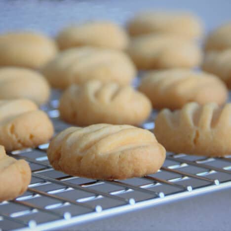 Looking across a cooling rack of the biscuits used to make a melting moment.
