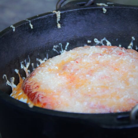 Looking across a Dutch oven with a baked tortilla lasagna inside.