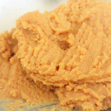 The peanut butter cookie dough sitting in a stainless bowl.