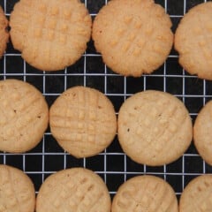 Looking down on a batch of peanut butter cookies cooling on a wire rack.