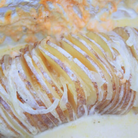 A close up photo of the cooked creamy baked potato sitting in a creamy sauce in the foil.