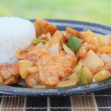 A camp plate of Chinese Five-Spice Chicken and Pineapple served with plain white rice.