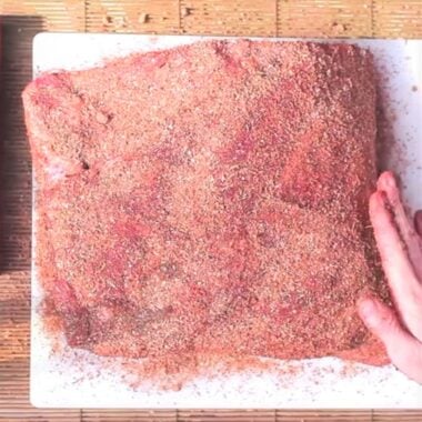 A raw lamb shoulder covered in the homemade lamb rub.