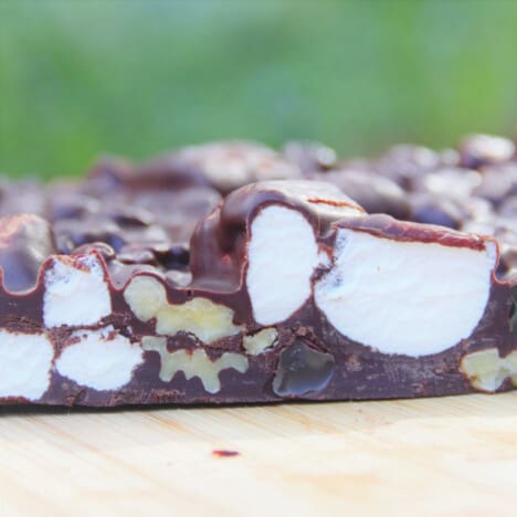 Looking into a slice of the chocolate rocky road, with large pieces of marshmallow and walnuts.
