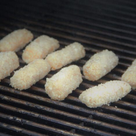 Fresh Mozzarella Sticks having just been placed on the BBQ grill to cook.