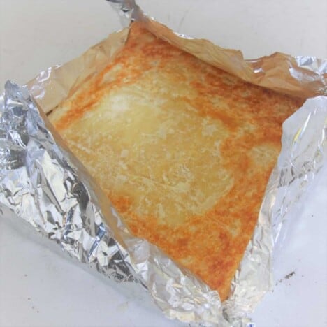 A foil custom made cake tin, the same size as the puff pastry, is holding the homemade vanilla slice before the icing layer is added.