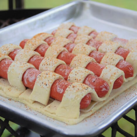 Looking down onto an unbaked hot dog tart on a baking sheet.