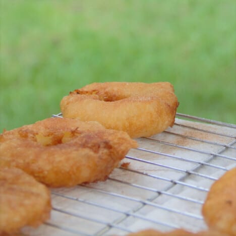 Cooked pineapple fritters resting on a cooling rack.