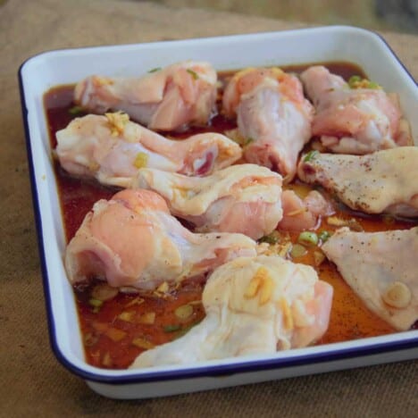 A pan of raw chicken wings marinates in a Chinese five-spice powder sauce.