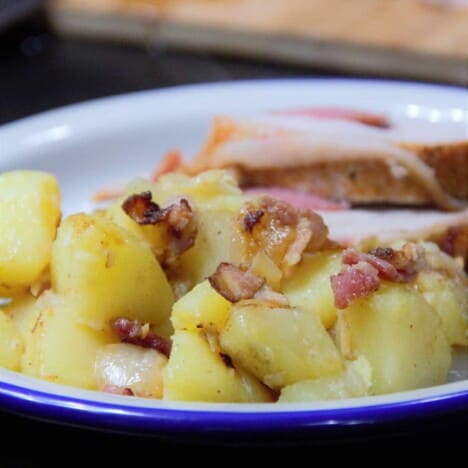 A close up image of the bacon potatoes on a camp plate as a side dish to a main meat.