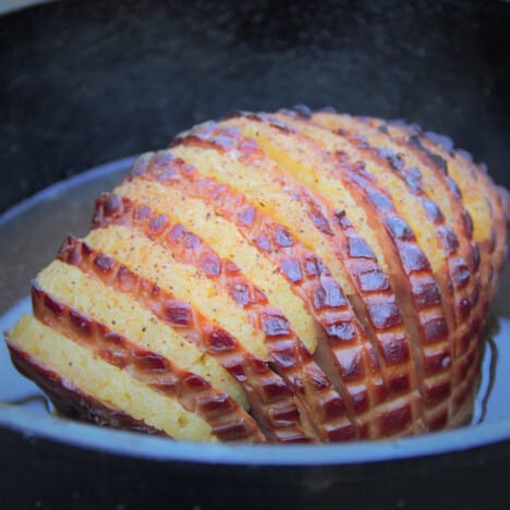 A Dutch oven with the whole ham showing the clear layers of the ham and pineapple.
