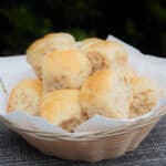 A white napkin lined basket filled with Wholemeal Bread Rolls.