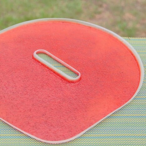 A flat tray from a dehydrator filled with fruit leather sitting on a picnic table