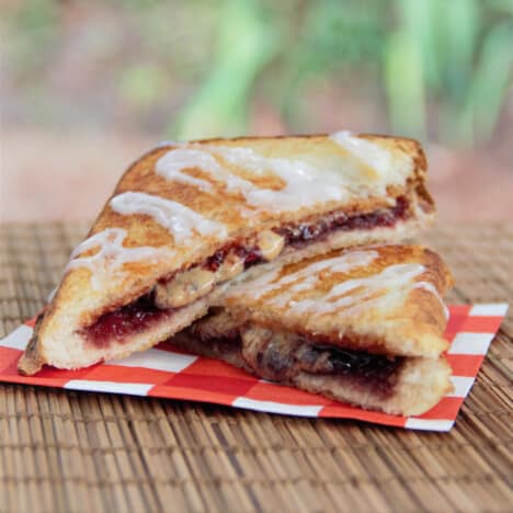 A campfire pop tart toastie is cut in half and served on a red checked napkin.