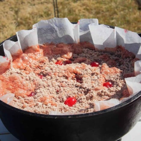 A Cheerwine Cherry Cola Chocolate Dump Cake prepared in a Dutch oven awaiting its lid and to be cooked.