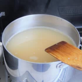 A stainless saucepan with the chicken and corn soup in it.