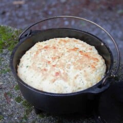 The cooked herb and garlic quick bread is sitting in an 8-inch Dutch oven that it was cooked in.