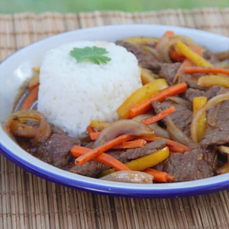 A camp plate with a serving of steamed white rice and stir fired beef and black bean sauce.