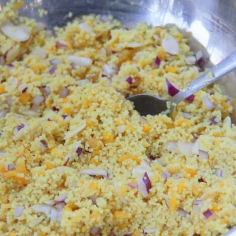 Closeup image of the apricot couscous sitting in a stainless bowl.