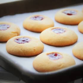 Jam drop cookies on a baking paper lined baking tray.
