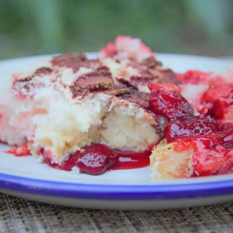 Looking across a camp plate with a generous serving of strawberry dump cake.