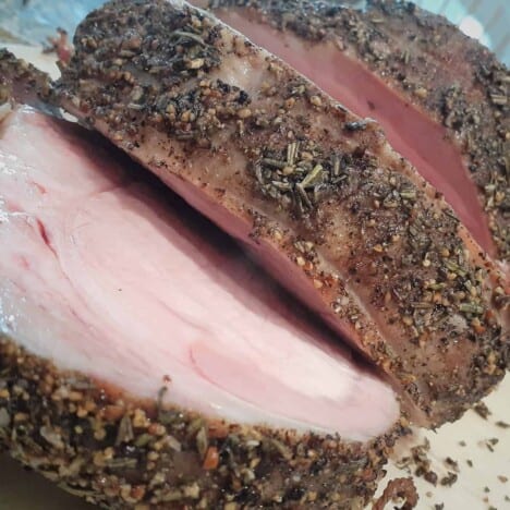 Looking into a cooked and sliced herb-crusted pork loin.