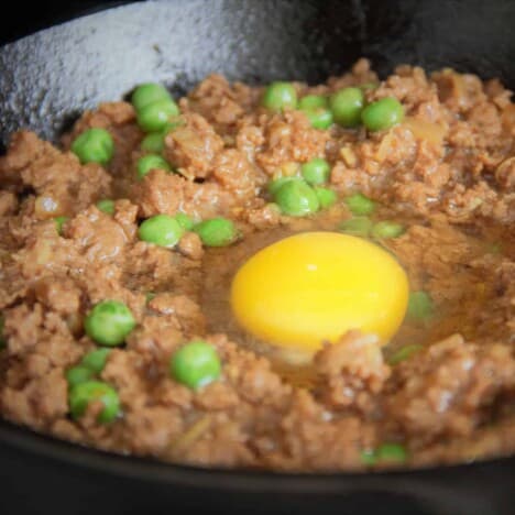 A raw egg cracked into a ground meant stew.