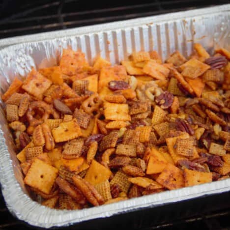 A close up shot of the barbecue party mix in a large foil tray.